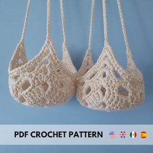 Può includere: Due portavasi sospesi all'uncinetto con un design bianco a trama aperta. I portavasi sono appesi su uno sfondo blu chiaro. Il testo "PDF CROCHET PATTERN" è nella parte inferiore dell'immagine.