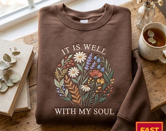Geborduurd sweatshirt met de tekst "It Is Well With My Soul", christelijk grafisch shirt met bloemenmotief en geloofscitaat.