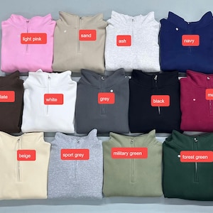 K&ouml;nnte beinhalten: Eine Auswahl an gefalteten Sweatshirts mit Viertelrei&szlig;verschluss in verschiedenen Farben: Hellrosa, Sand, Asch, Marine, Dunkelbraun, Wei&szlig;, Grau, Schwarz, Burgunderrot, Beige, Sportgrau, Milit&auml;rgr&uuml;n und Waldgr&uuml;n. Jedes Sweatshirt hat einen Rei&szlig;verschluss.