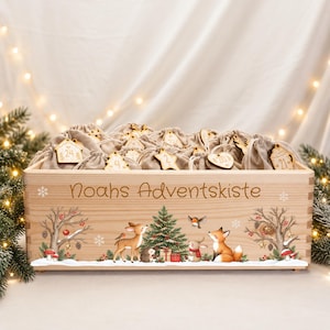 Könnte beinhalten: Eine rechteckige Holzkiste mit der Aufschrift Noahs Adventskiste, gefüllt mit kleinen beigen Stoffbeuteln mit Holzanhängern. Die Vorderseite zeigt eine bunte Illustration mit einem Weihnachtsbaum, einem Reh, einem Fuchs und einem Igel.