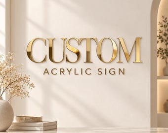 May include: A wall-mounted sign featuring the word CUSTOM in large, reflective gold serif lettering, with the words ACRYLIC SIGN in smaller, matching gold sans-serif text positioned directly underneath the primary word.