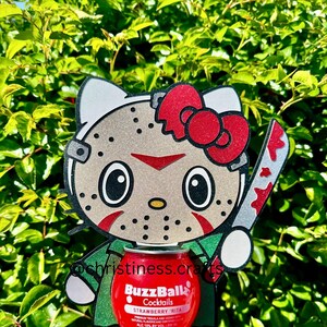 May include: A novelty item featuring a cartoon cat character with a hockey mask and a bloody knife. The character is holding a red BuzzBall cocktail can. The background is a green leafy bush.