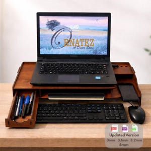 May include: A wooden laptop stand with a drawer, designed to elevate a laptop. The stand has a dark brown finish and includes a keyboard, mouse, and a smartphone. The laptop screen displays a landscape image. The text "GRANATEZ A Decor Store" is visible.
