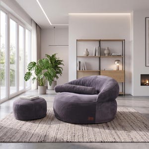 May include: A round, dark gray corduroy armchair with a matching cylindrical bolster pillow and a circular ottoman. The furniture features a textured, ribbed fabric finish and a low-profile, curved design, providing a soft seating arrangement.