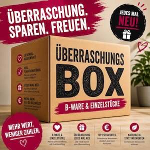 Könnte beinhalten: Ein brauner Pappkarton mit der schwarzen Aufschrift "ÜBERRASCHUNGS BOX B-WARE & EINZELSTÜCKE". Der Karton zeigt Symbole und deutschen Text mit Produktinformationen, darunter "LIEBEVOLL AUSGEWÄHLT", "VOLL FUNKTIONSFÄHIG" und "JEDES MAL NEU".
