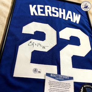 Può includere: Una maglia sportiva blu con il nome KERSHAW e il numero 22 in lettere bianche. Il numero 22 include una firma a inchiostro nero e il numero 22. Un certificato di autenticità Beckett è incluso con la maglia incorniciata.