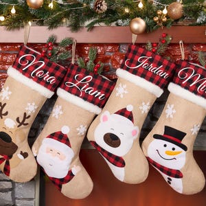 Puede incluir: Cuatro calcetines navideños personalizados con los nombres Nora, Liam, Jordan y Mira. Cada calcetín tiene una base de arpillera beige, un puño a cuadros rojos y negros y un ribete de piel sintética blanca. Diseños festivos: reno, Papá Noel, oso polar y muñeco de nieve.