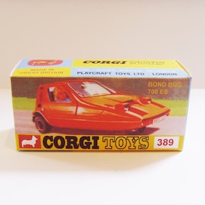 Puede incluir: Un modelo de coche rojo Bond Bug 700 ES de Corgi Toys en su caja original. La caja es amarilla y azul con el logotipo de Corgi Toys y el número de modelo 389.