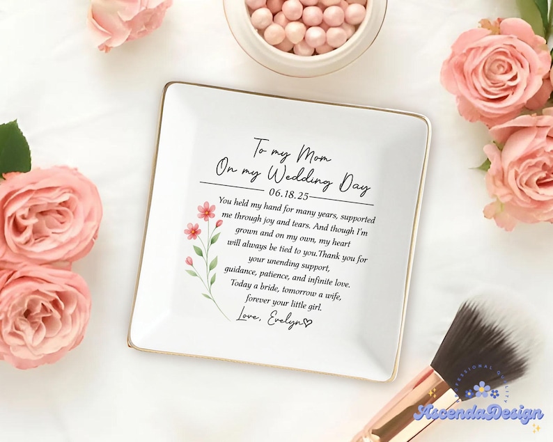 May include: A white square ceramic dish with a gold rim, featuring a heartfelt message to a mother on her wedding day. The dish is decorated with floral accents and surrounded by pink roses and makeup brushes.