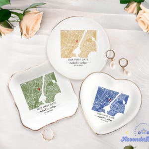 May include: Three white ceramic trinket dishes with gold rims, each featuring a map design and the text "OUR FIRST DATE" with a date and names. One dish is round, one square, and one heart-shaped.