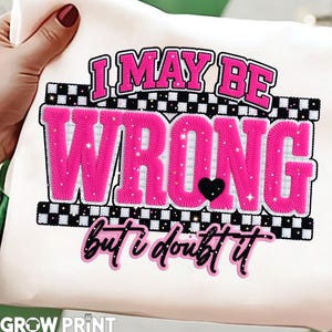 May include: White fabric with the text "I MAY BE WRONG but I doubt it" in pink, black, and white. The word "WRONG" is in large, textured pink letters with a black heart. The design has a checkered border.