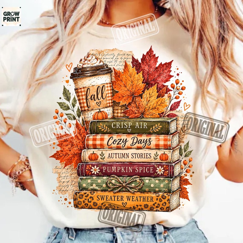 Puede incluir: Una camiseta de color crema con un gr&aacute;fico de una pila de cinco libros coronada por una taza de caf&eacute;. Los libros est&aacute;n etiquetados como Crisp Air, Cozy Days, Autumn Stories, Pumpkin Spice y Sweater Weather, rodeados de hojas de oto&ntilde;o y bayas.