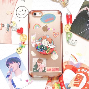 May include: Clear phone case with a variety of stickers, including rainbows, hearts, and a cartoon character with the word "HOPE." The case also features a photo of a person and the words "DAY DREAM."