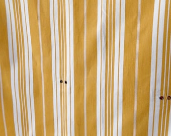 Peut inclure: Un tissu rayé jaune et blanc avec une texture subtile. Le tissu présente un motif rayé vertical avec de fines rayures blanches et des rayures jaunes plus larges.
