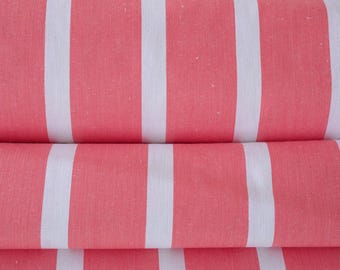 Peut inclure: Gros plan sur un tissu plié à rayures verticales. Le tissu présente des rayures alternées rose corail et blanches. La texture du tissu est visible, suggérant une matière douce. Les rayures sont espacées uniformément et créent un motif visuellement attrayant.