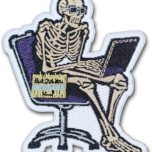 May include: Embroidered patch featuring a skeleton wearing glasses, seated in a purple office chair, and using a laptop. The patch includes the text "But Did You Actually Do Anything?" in yellow and blue. The patch has a white border.