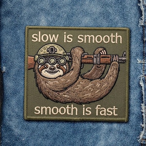 May include: Embroidered patch featuring a sloth wearing a helmet and goggles, holding a rifle. The patch is olive green with the text "slow is smooth" and "smooth is fast" in white.