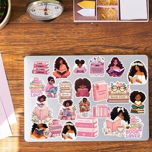 a laptop with a collection of stickers on its surface, depicting various female characters and themes related to reading and literature.