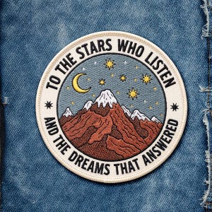May include: Embroidered patch with a mountain scene, a crescent moon, and stars. The text around the border reads, "TO THE STARS WHO LISTEN AND THE DREAMS THAT ANSWERED." The patch is circular with a cream-colored border and is set against a blue denim background.