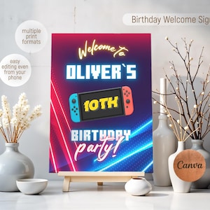 May include: A welcome sign for a 10th birthday party with a neon blue and red background. The sign features a Nintendo Switch controller with the text "Welcome to Oliver's 10th Birthday Party!"