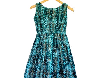Puede incluir: Un vestido sin mangas con estampado azul y marrón, cuello redondo y falda fruncida.