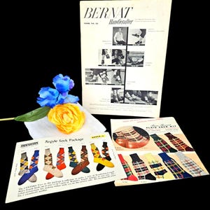 May include: A collection of vintage knitting pattern booklets titled Bernat Handicrafter Book No. 36 and Cynthia Argyle Sock Package, featuring illustrations of argyle and plaid socks, accompanied by a blue and yellow artificial flower arrangement.
