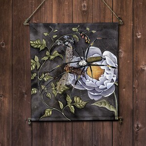 May include: A black and white spider with yellow markings sits on a white flower with green leaves and a web. The spider has long legs and is in a natural setting.