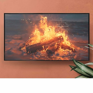 Peut inclure: Une image encadrée d'un feu de joie sur une plage la nuit. Les flammes sont orange et jaunes, et le sable est blanc. La mer est en arrière-plan.