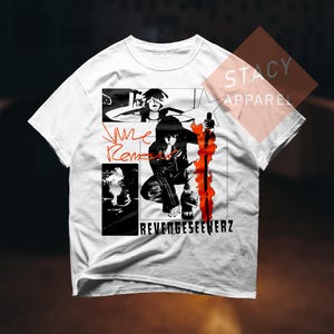 May include: White t-shirt with a black and red graphic design. The design includes a stylized illustration of a person, the text "RevengeSeekerz", and other graphic elements. The shirt has a crew neck and short sleeves.