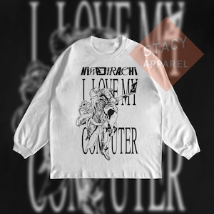Pode incluir: Camiseta branca de manga comprida com um design gráfico. O design apresenta o texto "NIMJIRACHI I LOVE MY COMPUTER" acima de uma ilustração em preto e branco de uma figura segurando um laptop. A camiseta tem gola redonda e mangas compridas.