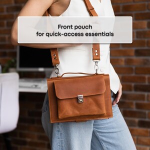 May include: A brown leather crossbody bag with a front pouch and silver-colored clasp. The bag has adjustable straps and is designed for quick-access essentials. The bag is worn over the shoulder.