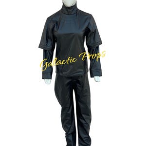 May include: A black costume displayed on a mannequin. The outfit includes a high-collared top with layered sleeves and matching pants. The text "Galactic Props" is visible in yellow script across the front of the outfit.