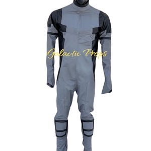 May include: Gray and black jumpsuit with a high collar and long sleeves. The jumpsuit has black accents on the shoulders, knees, and sleeves. The text "Galactic Props" is printed on the front.