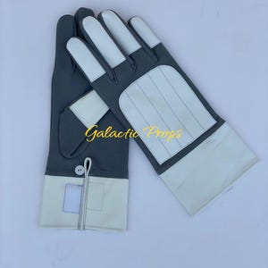 May include: A pair of gloves with a gray and white color scheme. The gloves have white fingertips and a white panel on the back of the hand. The text "Galactic Props" is visible in the image.