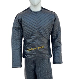 Puede incluir: Chaqueta y pantal&oacute;n de cuero acolchado negro con un logotipo bordado en oro que dice "Galactic Props".