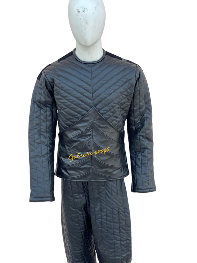 Puede incluir: Chaqueta y pantal&oacute;n de cuero acolchado negro con un logotipo bordado en oro que dice "Galactic Props".