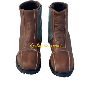 Puede incluir: Un par de botas de cuero marr&oacute;n con un panel de cuero azul en la parte posterior de cada bota. Las botas tienen una suela de goma negra y una cremallera en el interior de cada bota.