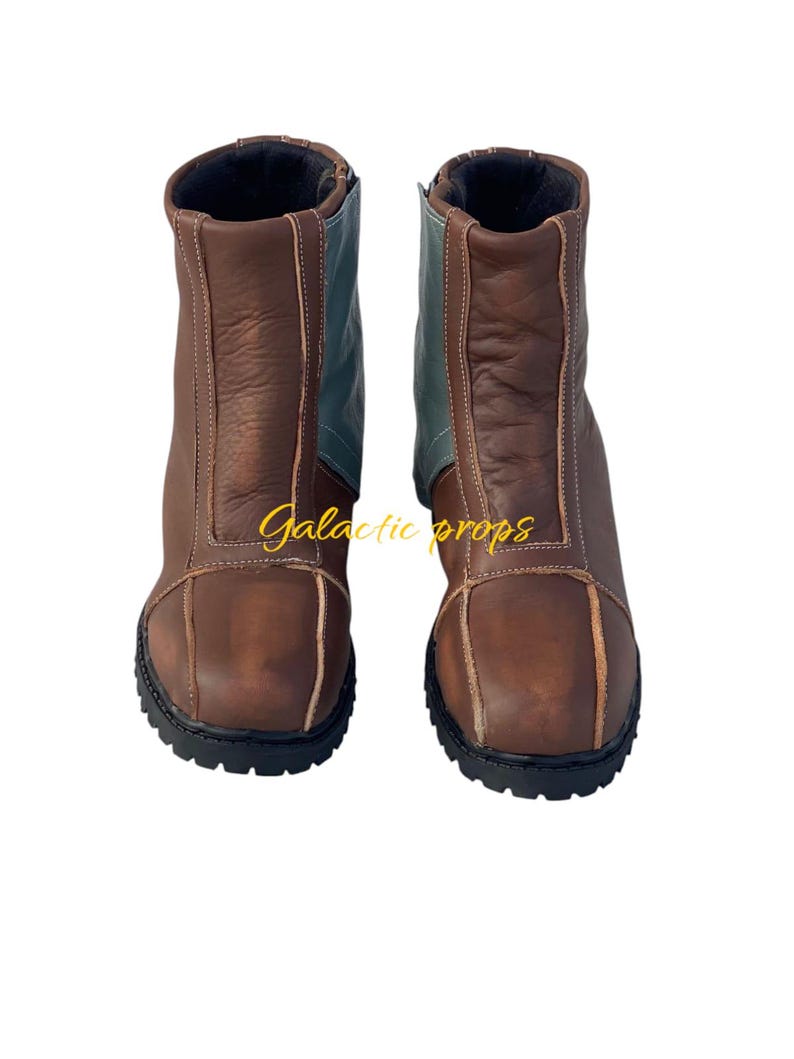 Puede incluir: Un par de botas de cuero marr&oacute;n con un panel de cuero azul en la parte posterior de cada bota. Las botas tienen una suela de goma negra y una cremallera en el interior de cada bota.