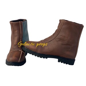 Puede incluir: Un par de botas de cuero marr&oacute;n con una cremallera en el lateral. Las botas tienen una suela de goma negra y una parte superior de cuero marr&oacute;n.