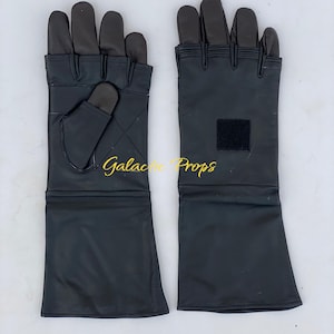 May include: A pair of black leather gloves with long cuffs. The gloves have dark brown fingertips and a small square patch on one cuff. The text "Galactic Props" is visible.