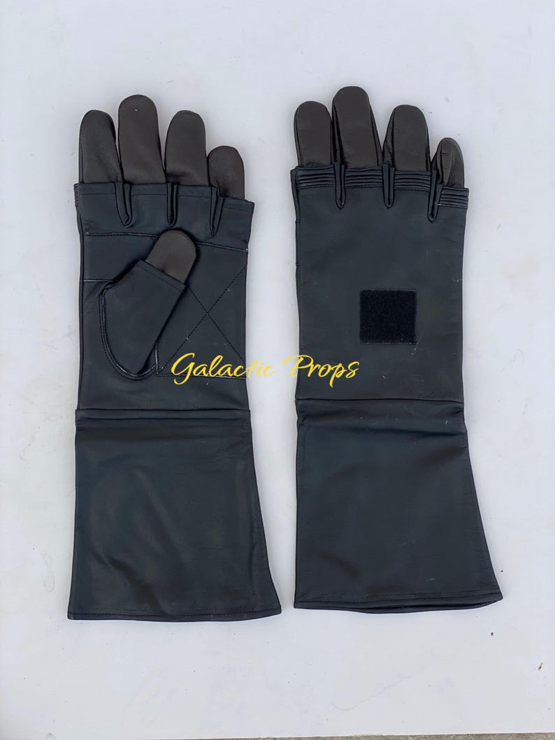 May include: A pair of black leather gloves with long cuffs. The gloves have dark brown fingertips and a small square patch on one cuff. The text "Galactic Props" is visible.