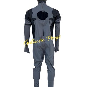 May include: A gray and black jumpsuit with a black hood. The jumpsuit has a geometric design on the back and sleeves. The text "Galactic Props" is visible in the image.