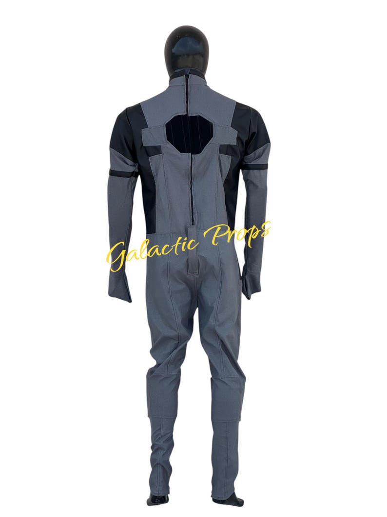 May include: A gray and black jumpsuit with a black hood. The jumpsuit has a geometric design on the back and sleeves. The text "Galactic Props" is visible in the image.
