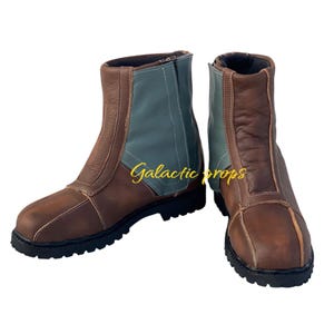 Puede incluir: Un par de botas de cuero marr&oacute;n con un dise&ntilde;o de bloques de color azul y marr&oacute;n. Las botas tienen una cremallera en el lateral y una suela de goma gruesa.