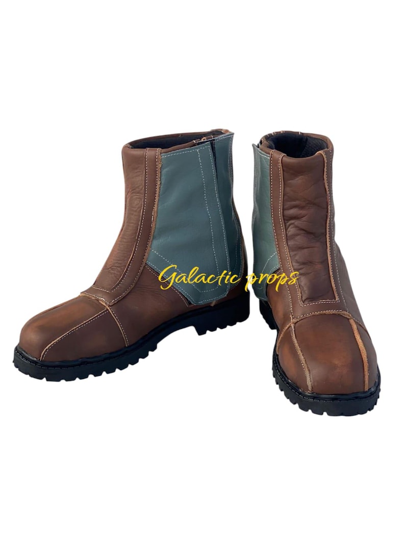 Puede incluir: Un par de botas de cuero marr&oacute;n con un dise&ntilde;o de bloques de color azul y marr&oacute;n. Las botas tienen una cremallera en el lateral y una suela de goma gruesa.
