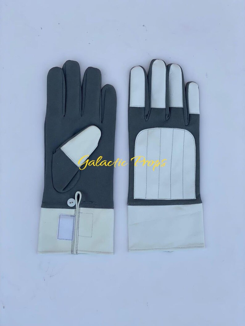 May include: A pair of gray and white gloves. The gloves have a gray main color with white accents on the fingers, cuffs, and a small patch on the back of the hand. The text "Galactic Props" is visible.
