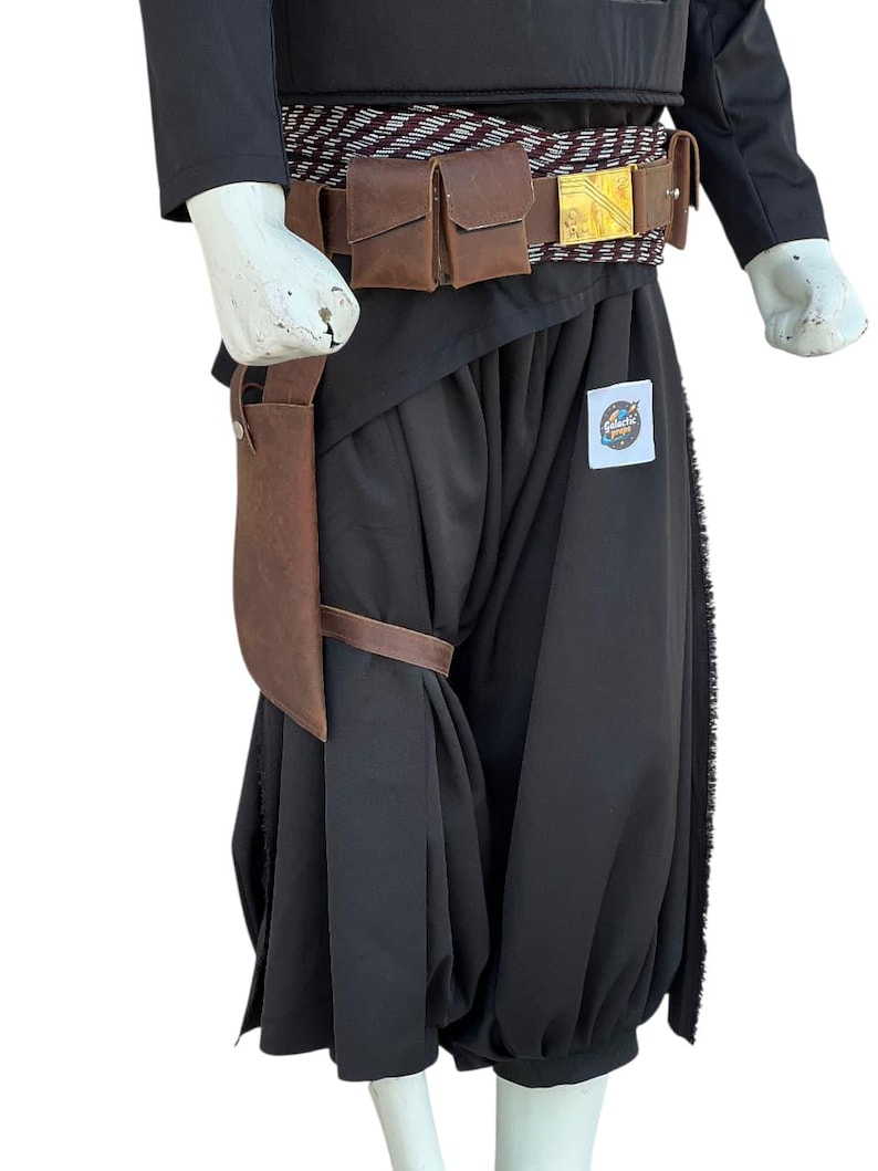 Pu&ograve; includere: Un costume nero con tasche in pelle marrone e una cintura con fibbia dorata. Il costume comprende un top nero, pantaloni e una fondina in pelle marrone. Il costume ha una toppa Galactic Empire.