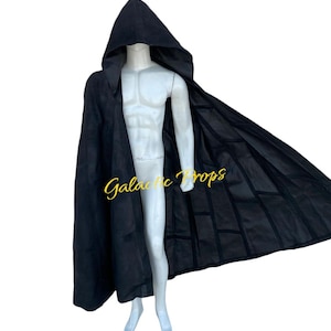 Puede incluir: Una capa negra con capucha con un diseño largo y fluido. La capa está drapeada sobre un maniquí. El texto "Galactic Props" es visible en la capa. La capa parece estar hecha de una tela oscura y suave.