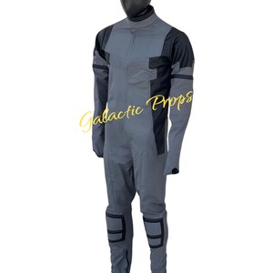 May include: A gray and black jumpsuit with a high collar, long sleeves, and knee pads. The suit is displayed on a mannequin. The text "Galactic Props" is visible in the image.
