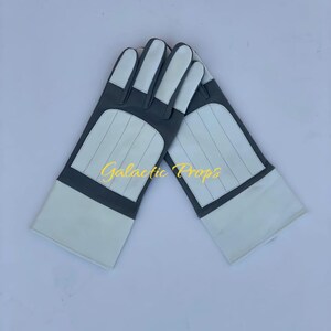 May include: A pair of white and gray gloves with the text "Galactic Props" in yellow. The gloves have white fingertips and cuffs, with gray panels and stitched details.